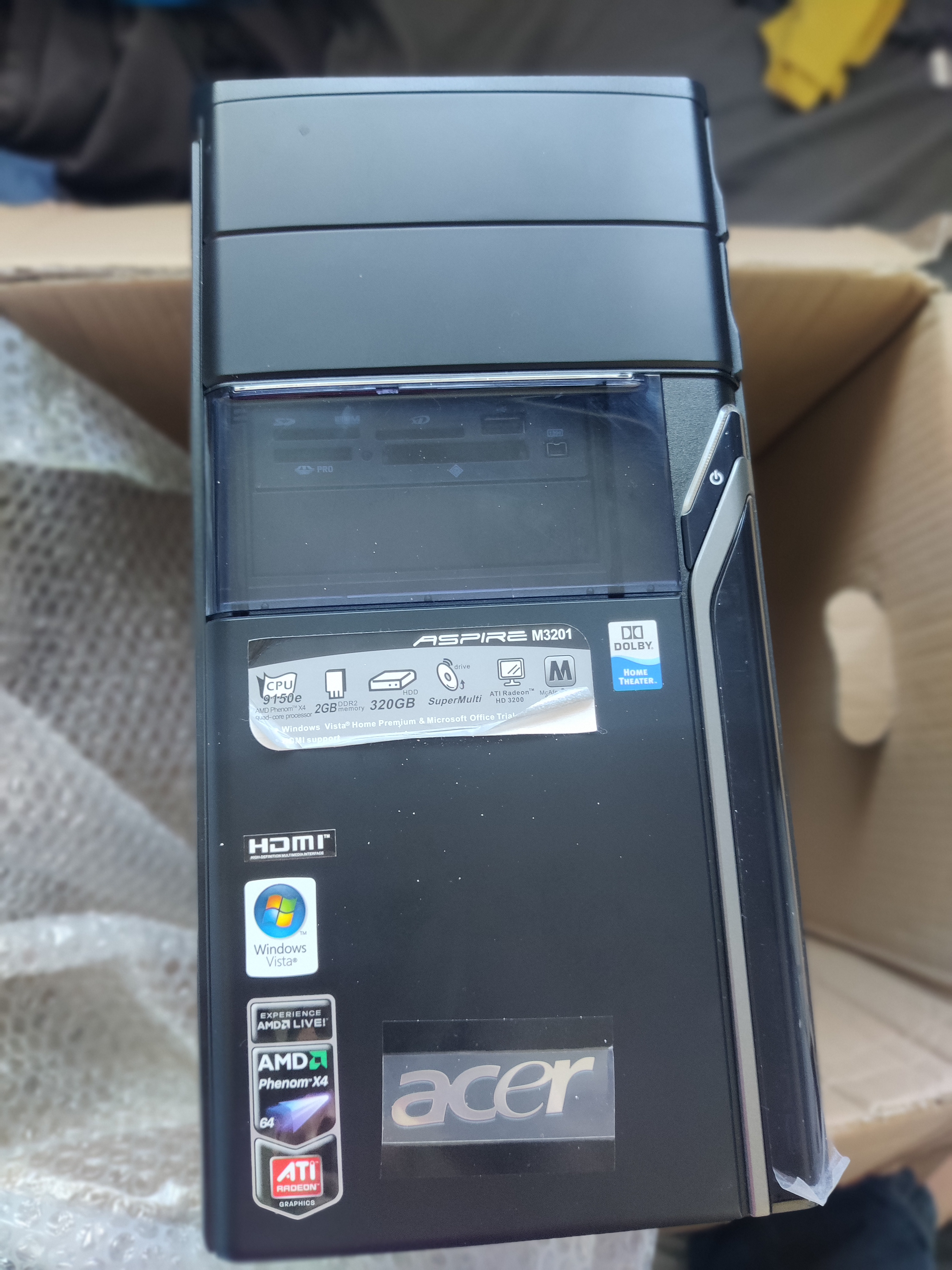 The front of the case, with two optical drive ports, protective stickers still on and with the original advertising stickers still on